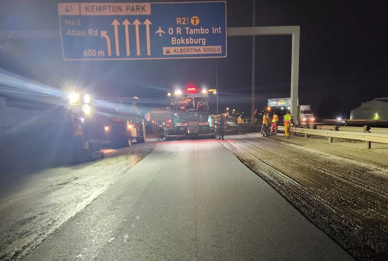 Asphalt roadworks near R21 signs at night